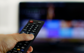 Photographie d'une télécommande devant une télévision