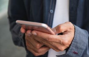 Photographie d'une personne tenant un téléphone portable dans ses mains